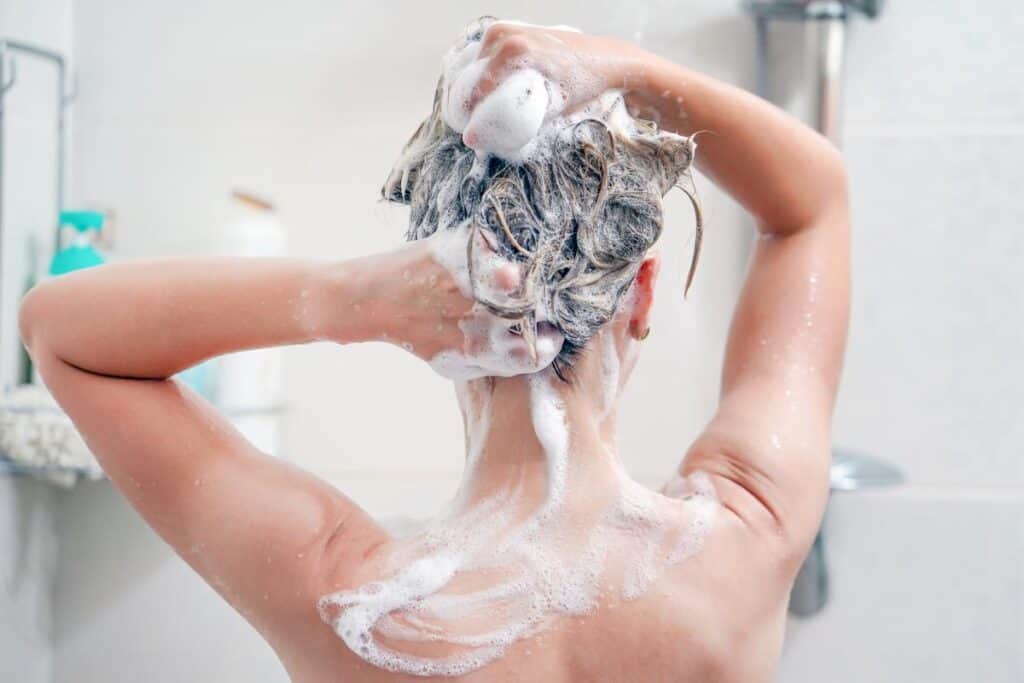 persona lavándose el pelo