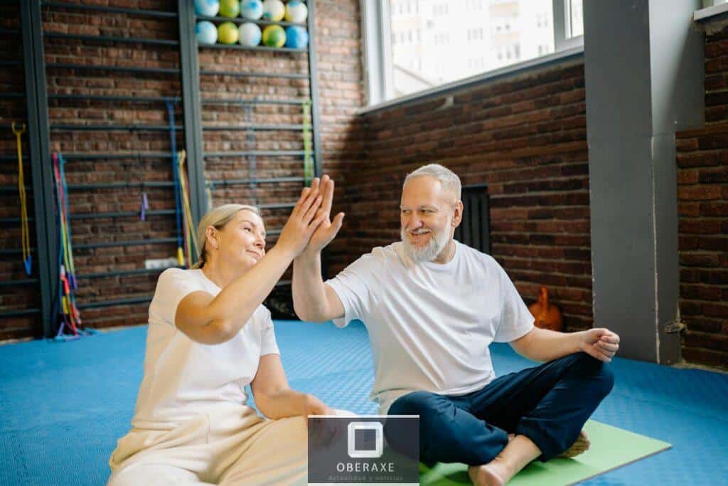 An Elderly Couple High Fiving each other while Sitting in the Gym